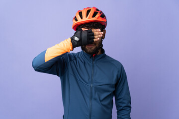 Young Moroccan cyclist man isolated on purple background covering eyes by hands. Do not want to see something