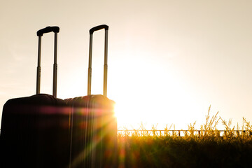 Silhouette of Travel suitcases, luggage or baggage on 
Sunrise or Sunset background,The journey and  vacation concept or business travel, Hitchhiking to travel concept