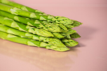 green asparagus on pink background, vegetables