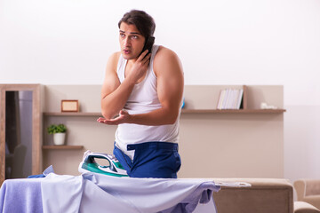 Young male employee ironing in the morning