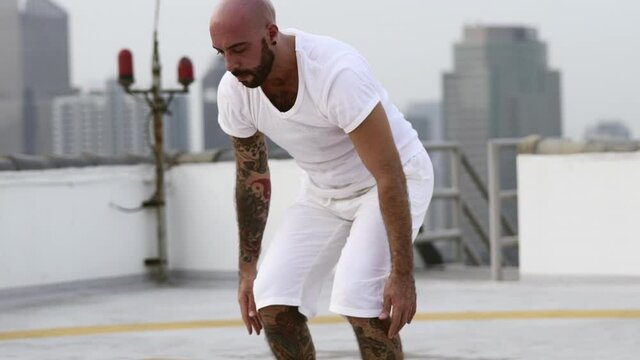 Man Stands Upright From Bending Forward And His Fingers Touching The Ground
