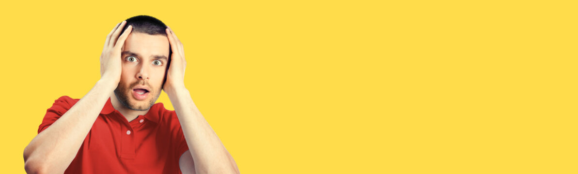 Unbelievable bad terrible news! Unhappy shocked panic man, isolated over yellow colour background. Emotions and unsuccess concept. Excited male model with rise up hands, red casual clothing at studio.