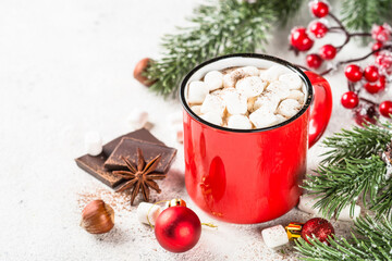 Obraz na płótnie Canvas Christmas drink. Hot chocolate with marshmallow in red mug and christmas decorations at white table.