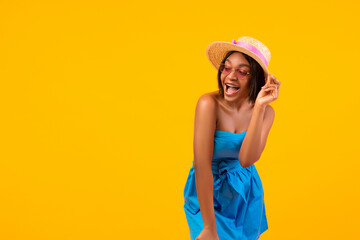 Sexy black lady having fun, wearing stylish clothes, feeling playful in summertime over orange background, copy space