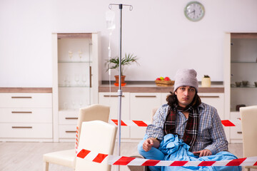 Young sick man suffering at home in pandemic concept