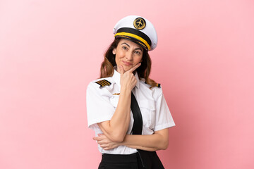 Airplane middle aged pilot woman isolated on pink background smiling