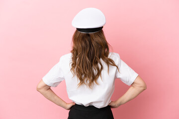 Airplane middle aged pilot woman isolated on pink background in back position
