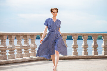 Full length portrait of young beautiful woman in blue dress