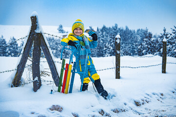 Child playing with snow in winter