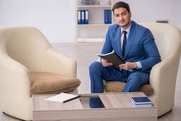 Young male employee waiting for business meeting