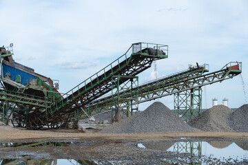 Fototapeta na wymiar Industrial background - crusher (rock stone crushing machine) at open pit mining and processing plant for crushed stone, sand and gravel