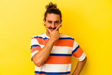 Young caucasian man with long hair isolated on yellow background contemplating, planning a strategy, thinking about the way of a business.