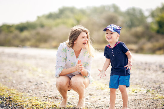 Happy Mother and son have a rasting at the beach