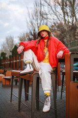 Teenager girl in colorful youth urban style clothes on city street