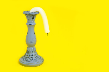 Candle Holder with a Drooping Candle on a Yellow Background Concept Impotence Impotence and Old Age in Sex - obrazy, fototapety, plakaty