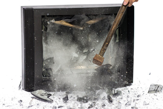 Hammer blow to television, shards flying away, white background. Breaking TV screen.