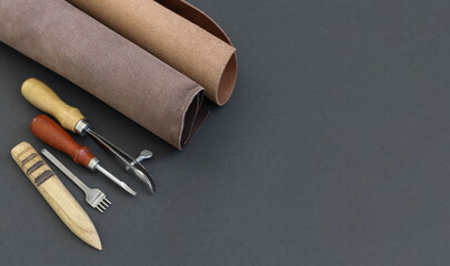Pieces of the leather and tanner's tools on the working desk in the leather workshop. View from...