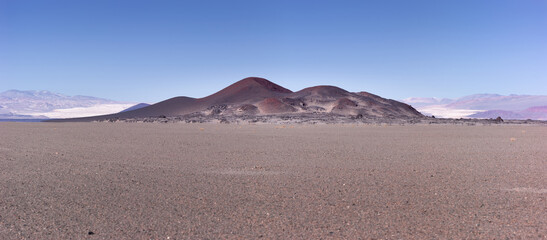 Panoramic image of a volcanic cinder cone with the white solidified lava flow of Campo de Piedra...