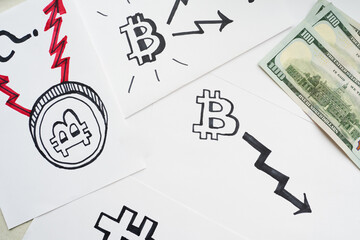 Bitcoin Pricing Fall Concept. Sheets of paper with a variety of bitcoin logos and arrows, which reflect positive and negative trends in the cryptocurrency sphere..