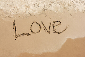 Inscription Love drawn on the sand. Concept of true and honest romantic feelings. spa novel on the sea.