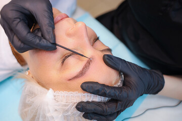 Tattoo Artist combs client's eyebrow with microbrash