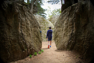 Boy climbing rocks in a park in the summer