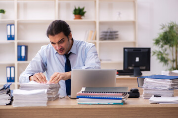 Fototapeta premium Young male employee and too much work in the office