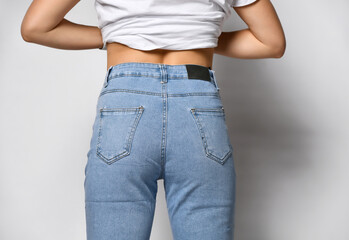 Fit female butt in jeans with passport in pocket and white t-shirt