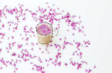 Romantic spring. Cup of coffee with purple lilac on white background.