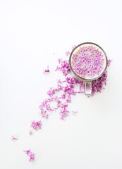 A cup of hot morning coffee and lilac flowers on a white background. View from above. Close-up. Copy space for text. The concept of holidays and good morning wishes.