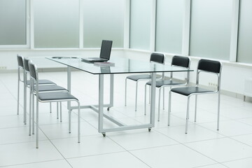 Laptop on glass table in spacious office space
