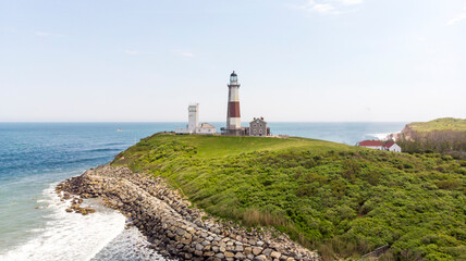 White lighthouse with brick on the ocean with a green lawn © Benjamin