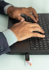 executive man typing and  a pen drive inserted in a computer