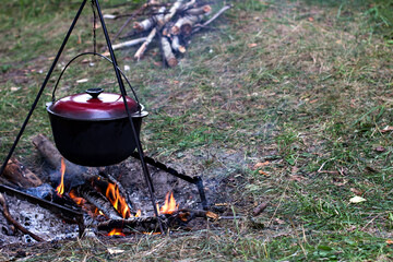 A pot over the fire. Summer vacation, hike, tourism - 436735322