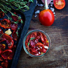 sun-dried tomatoes. Sun-dried tomatoes with herbs and garlic on a wooden background. - 436735764