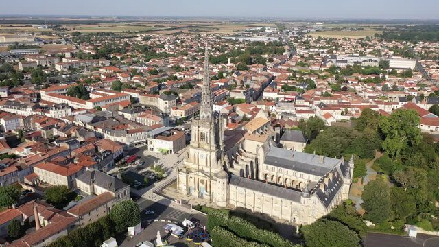 Picturesque summer view of Lucon looking out over Roman Catholic cathedral with tall Gothic bell tower, France