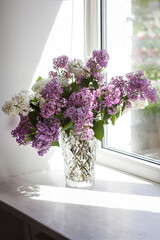 Vase with a bouquet of lilacs on the window. - 436736335