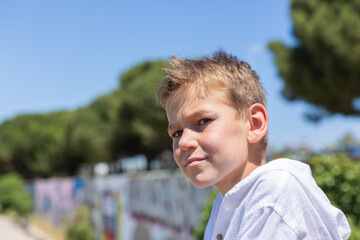 Handsome young boy, teenager is sitting outdoors and looking around