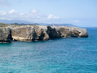 Fototapeta premium Vistas de la costa de Asturias en España, desde los acantilados de los Bufones de Prias, con paisaje rocoso, y aguas azules, en las vacaciones de verano de 2020