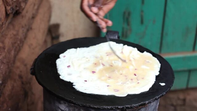 Flying the eggs and turning them up and down to ensure that every part of the egg is ready  when making the African Street Rolex