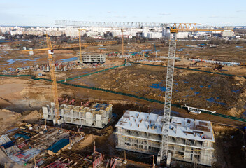 Tower cranes in action at construction site. Crane during formworks. Soil Compactor leveling ground...