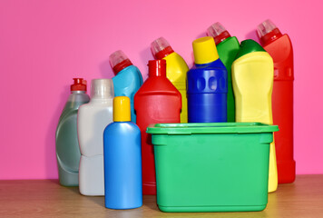 Detergent bottles on pink background. Detergents and laundry concept. Household chemicals for...