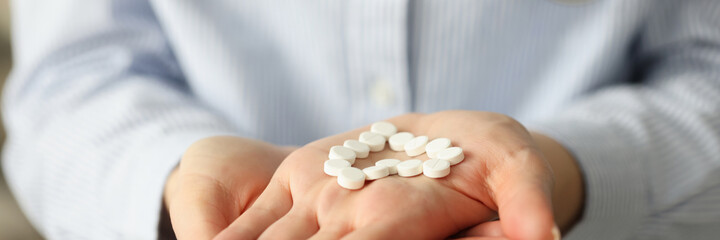 Doctor holding heart shaped pills in hand closeup