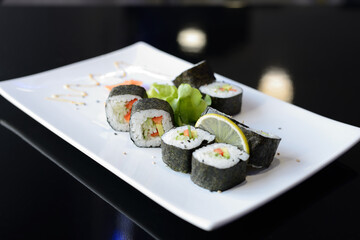 Sushi rolls on white dish. Japanese food.