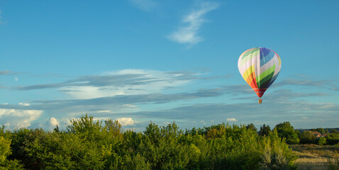Balloons fly over the green fields, nature hills in summer