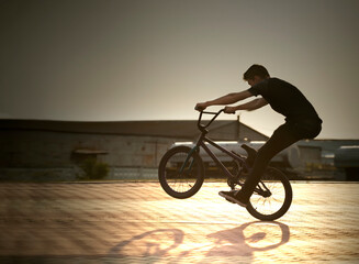 teenager silhouette jump on a bicycle summer outdoors