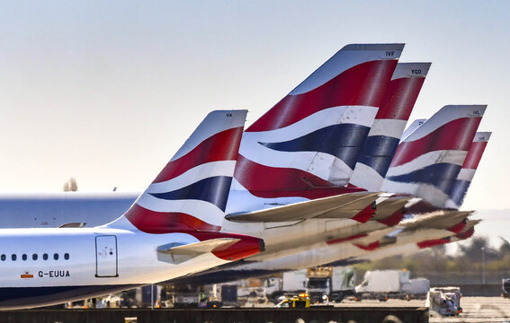 London, England - March 2019: Tail fins of British Airways jets lined up at London Heathrow Airport.