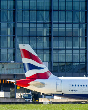 British Airways Airbus A319 Airliner Taxiing Past The Terminal 5 Building At London Heathrow Airport.