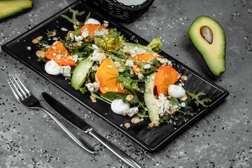Fresh salad with fruits and greens on dark canvas background. Healthy food