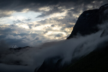 Mountains buried in fog around Lake Bohinj in Slovenia during colorful sunset